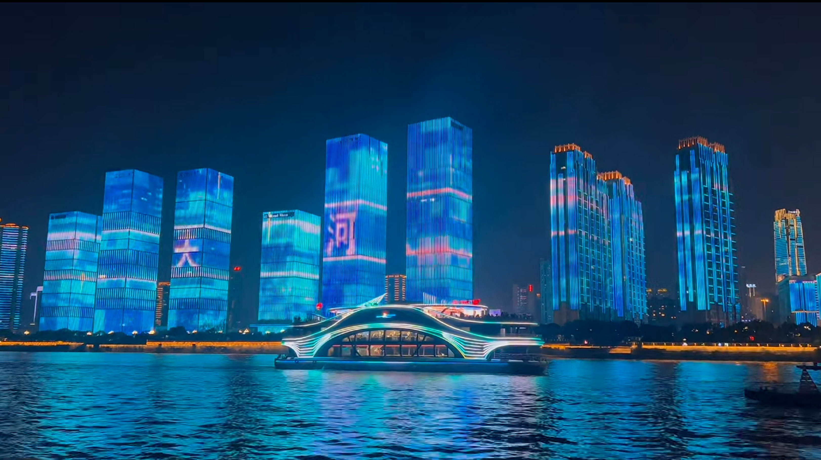 Illuminated buildings and a boat on the river